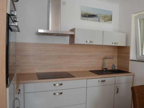 a kitchen with a sink and a counter top at Cutter in the shiphouse in Hooksiel