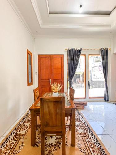 a dining room with a wooden table and chairs at Teras Senja Sikunir Homestay in Kejajar