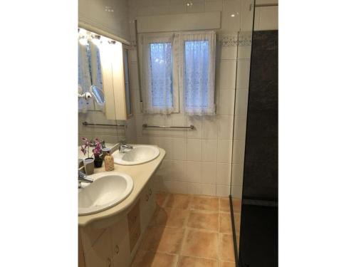 un bagno con due lavandini e una doccia di Casa Ayelen Comfortable holiday residence a Vinarós