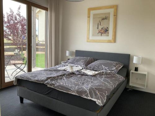a bed with a gray comforter in a bedroom at Lake idyll Comfortable holiday residence in Repente