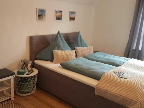 a bed with blue sheets and pillows on it at FeWo Nero Comfortable holiday residence in Niebüll