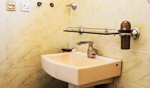 a bathroom with a white sink in a room at HUNZA Mountain HOTEL in Gircha
