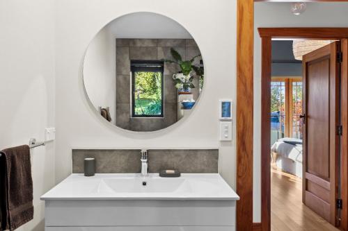 een badkamer met een wastafel en een spiegel bij Supplejack Gardens in Upper Moutere