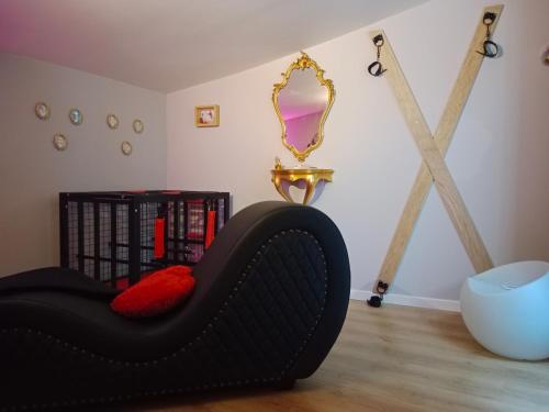 Pokój z czarnym krzesłem i lustrem w obiekcie Love Room Ange ou Démon à Aulnat w mieście Aulnat