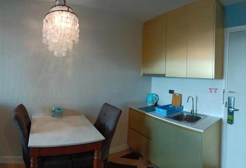 a kitchen with a table and a sink and a chandelier at Espana Condo Resort By K&T in Jomtien Beach