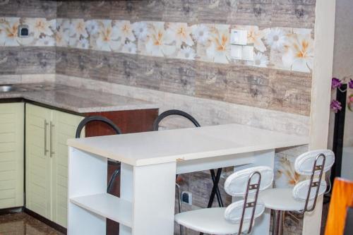 - une cuisine avec une table et des chaises blanches dans l'établissement House of ours Dreams, à Abomey-Calavi