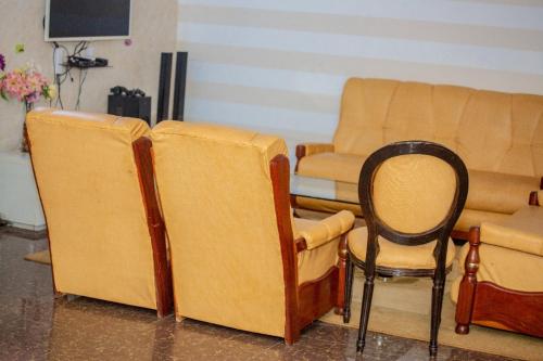 - un salon avec deux chaises et une chaise dans l'établissement House of ours Dreams, à Abomey-Calavi