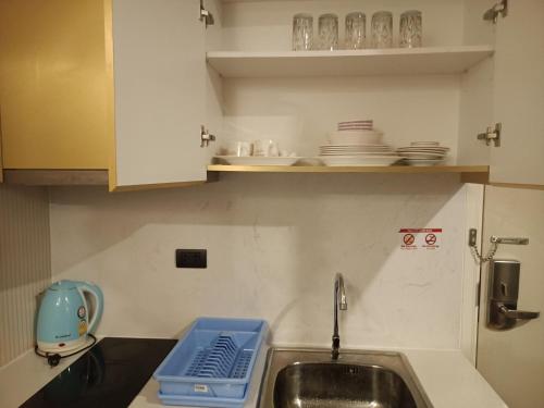 a kitchen with a sink and a counter with dishes at Espana Condo Resort By K&T in Jomtien Beach