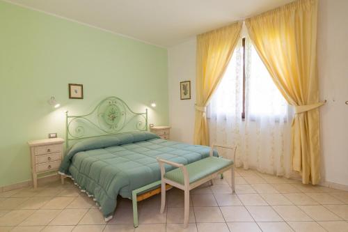 een slaapkamer met een groen bed en een raam bij Il Girasole - Corbezzolo in Venturina Terme