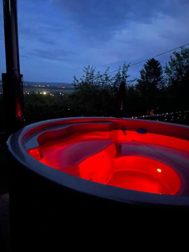 a hot tub with red lights in the dark at Panoráma Nyaraló in Tahitótfalu