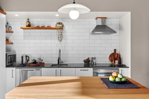 a kitchen with a wooden table with a bowl of fruit at Supplejack Gardens in Upper Moutere