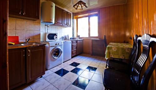 eine Küche mit einer Waschmaschine und einem Fenster in der Unterkunft Lessor Apartments in Almaty