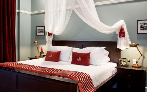 a bedroom with a bed with red and white pillows at Grand Pacific Hotel in Suva