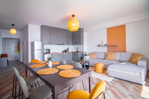 a kitchen and a living room with a table and chairs at Modern Central Seaview Apartment Saranda in Sarandë