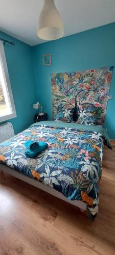 um quarto com uma cama com um edredão colorido em Charmante petite maison em Torcenay