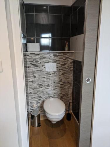 La salle de bains est pourvue de toilettes blanches. dans l'établissement Au bout du Ciel - Maison avec garage, terrasse, cave, à Savigny-lès-Beaune