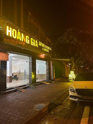 HOÀNG GIA Hotel ĐÔNG ANH في Dong Anh: واجهة محل مع سيارة متوقفة أمامه