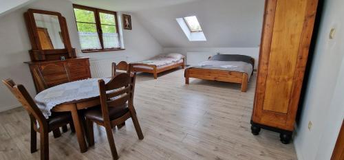 1 dormitorio con 2 camas, mesa y sillas en Green Wilow Siedlisko, en Wrocanka