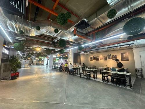 a room with people sitting at tables in a restaurant at 2BR, 1 Car Park, 4Pax Seaview 118IslandPlaza in Tanjong Tokong