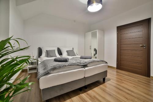 Willa Bania Rabka Zdrój - Bezpłatny całodzienny basen - blisko centrum - Widok na Babią Górę في رابكا: غرفة نوم مع سرير وأرضية خشبية