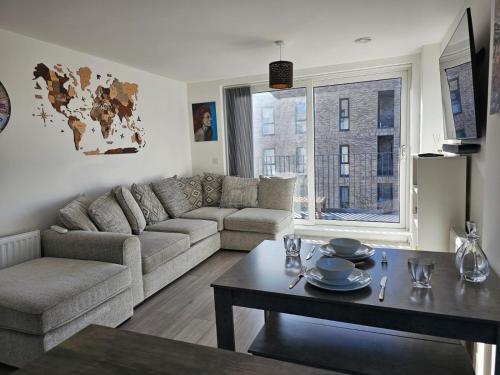 a living room with a couch and a table at Luxury 1-Bed Apartment with balcony & Free parking in Milton Keynes