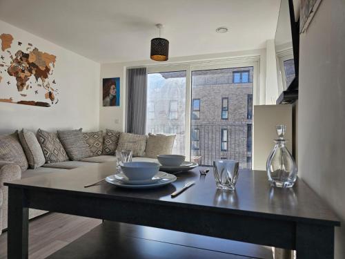 a living room with a table and a couch at Luxury 1-Bed Apartment with balcony & Free parking in Milton Keynes