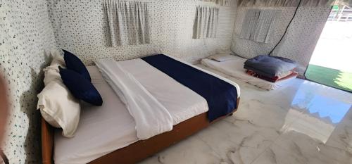a bedroom with a large bed with blue pillows at Welstays Beas River in Manāli