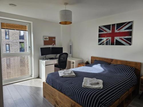 1 dormitorio con cama y escritorio en Luxury 1-Bed Apartment with balcony & Free parking, en Milton Keynes