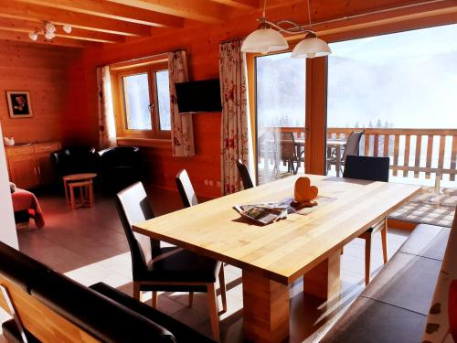 comedor con mesa de madera y sillas en Ferienhaus Lärchenhütte en Kasperle