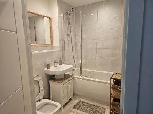 y baño con aseo, lavabo y ducha. en Luxury 1-Bed Apartment with balcony & Free parking, en Milton Keynes