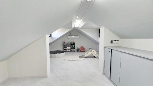 an attic hallway with white walls and white floors at Check-in Jeju Private Full Stay in Jeju
