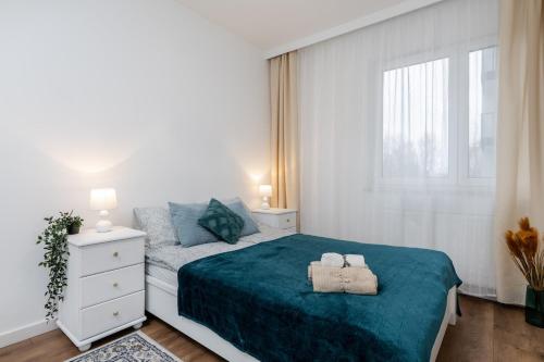 a bedroom with a bed with two towels on it at Cayenne Premium Apartment Airport in Warsaw