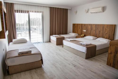 a hotel room with two beds and a balcony at Bartu Otel in Cesme