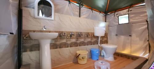 a bathroom with a sink and a toilet in a tent at Welstays Beas River in Manāli