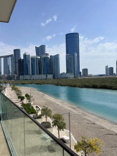 a view of a beach with a city in the background at Enjoy Luxury Condo with Sea View in Abu Dhabi