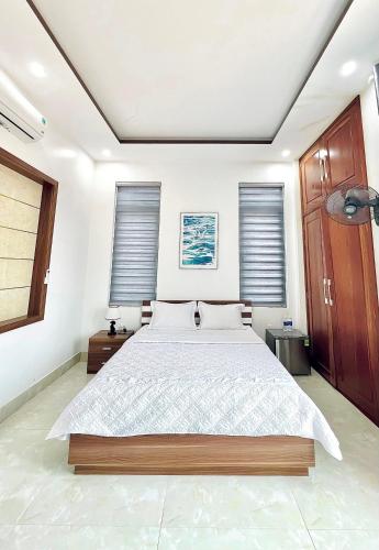 a bedroom with a large bed and two windows at 150 Homestay in Dong Hoi