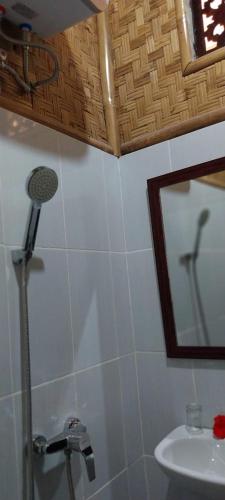 a bathroom with a shower and a mirror and a sink at Pondok Sapta Sallaca in Selat