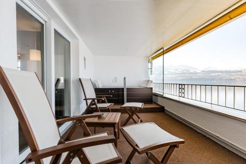 eine Sitzreihe auf einem Balkon in der Unterkunft BEATUS Wellness- & Spa-Hotel in Merligen
