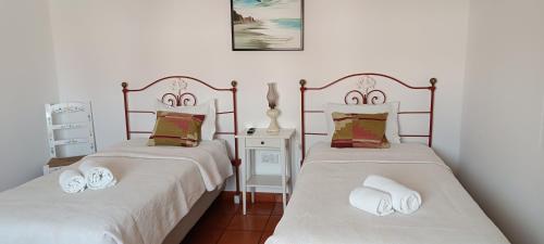 2 bedden in een kamer met witte lakens bij Casa das Hortências By Alojamentos Vitinho - Vila Nova MIlfontes in Vila Nova de Milfontes