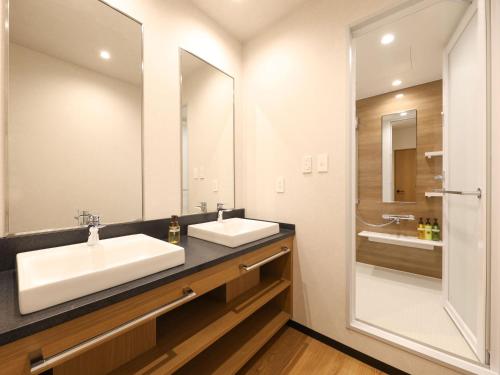 La salle de bains est pourvue d'un lavabo et d'un miroir. dans l'établissement HOTEL MYSTAYS Kumamoto Riverside, à Kumamoto