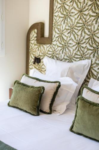 a bed with white pillows and a headboard at Lou Cagnard in Saint-Tropez