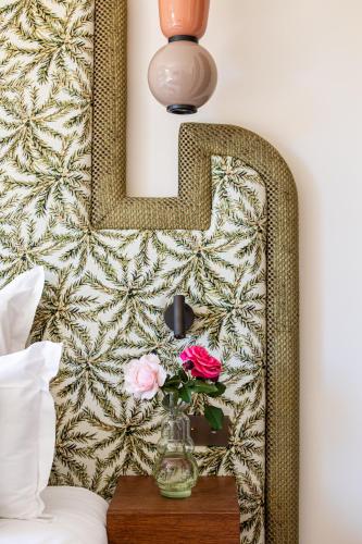 a vase of flowers on a table with a letter at Lou Cagnard in Saint-Tropez