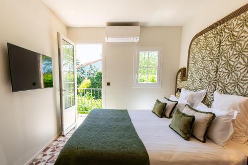 a bedroom with a large bed and a television at Lou Cagnard in Saint-Tropez