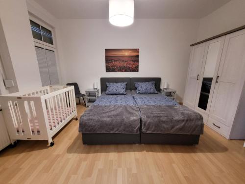 オーバーハウゼンにあるWohnung in Oberhausen: zentral & ruhig, eigener Eingangのベッドルーム(ベッド1台、ベビーベッド1台付)