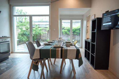une salle à manger avec une table avec des chaises et une télévision dans l'établissement Etape 37, à Tours