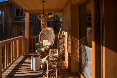a porch with wicker chairs and a chandelier at Alpegg Chalets in Waidring