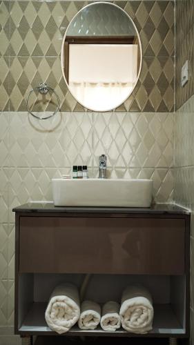 a bathroom with a sink and a mirror at Saanjh Cottages in Bīr