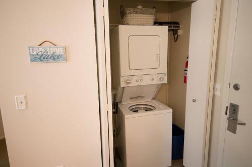 uma máquina de lavar e secar roupa num pequeno quarto em Gorgeous Grand Traverse Bay Beach Front Condo em Traverse City