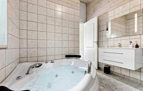 a bath tub in a bathroom with a sink at 3 Bedroom Awesome Home In Ebeltoft in Ebeltoft