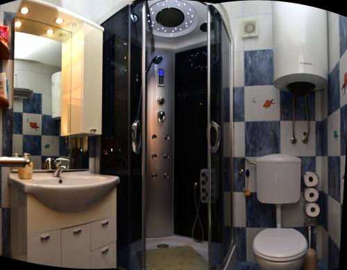 a bathroom with a shower and a sink and a toilet at Apartments " Happy villa " in Splitska